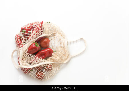 Wiederverwendbare mesh String aus Gewirken Einkaufstasche mit Tomaten und Paprika. Null Abfall Konzept. Umweltfreundlich. Stockfoto