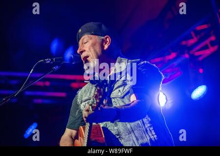 Sidmouth, 8.. Aug 19 die Folk-Rock-Legende Richard Thompson spielt zu einem vollen Konzert beim Sidmouth Folk Week Festival in der Hauptpromenade "Ham". Aufgrund des schlechten Wetters wurde der Hauptort unmittelbar nach seiner Vorstellung geschlossen. Weitere Veranstaltungen werden eine Meile landeinwärts zum kleineren Veranstaltungsort in Bulverton verlegt, weg von der vollen Kraft des eintreffenden Sturms. Stockfoto