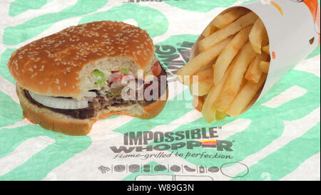 Unmöglich Whopper von Burger King mit einem Bissen genommen und Pommes frites auf Wrapper Stockfoto