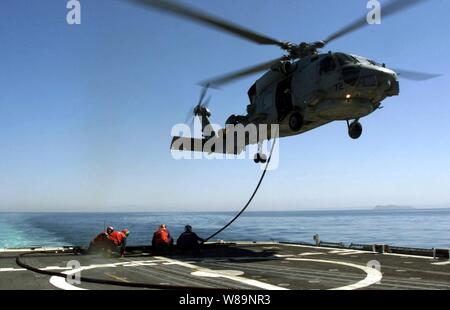 Segler und das Bodenpersonal in die Lage zu leichten Hubschrauber Anti-Submarine Squadron 47 Verhalten hot-Versorgung in Flug eines SH-60B Seahawk Helikopter vom Deck der USS Antietam (CG-54), während sich das Schiff auf See am 22. März 2000 läuft. Hot-Versorgung in Flug ist erforderlich, wenn die Landung auf einem kleineren US Navy Schiff zu tanken zu gefährlich für das Schiff, Hubschrauber- und Flugpersonal sein würde. USS Antietam ist ein ticonderoga Klasse Cruiser in San Diego, Calif. homeported Der Seahawk ist an der Naval Air Station North Island, Calif. basierend Stockfoto