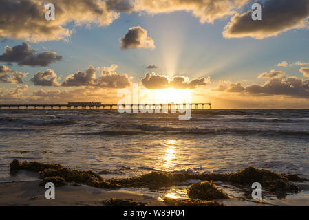 Wolken über dem Ozean und dem Ocean Beach Pier während einer lebhaften Sonnenuntergang. Blick vom Strand. San Diego, Kalifornien, USA. Stockfoto