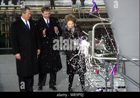 Ehemalige First Lady Nancy Reagan zerschlägt die traditionelle Flasche Sekt am Bug, als sie tauft der U.S. Navy neueste Flugzeugträger Ronald Reagan (CVN 76) am 4. März 2001 in Newport News, Virginia. Präsident George W. Bush und Chairman und Chief Executive Officer von Newport News Shipbuilding William S. Frick seit Reagan in der Zeremonie. Die Atomgetriebenen Schiff, zu Ehren des 40-jährigen Präsidenten benannt, wird bei Newport News Shipbuilding gebaut. Stockfoto