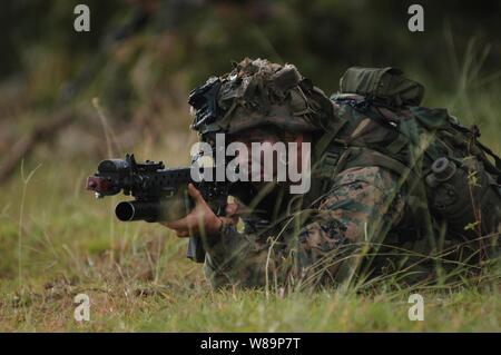 Ein Marine aus dem 3. Marine Regiment Brände auf oppositionelle Kräfte während der Taktischen Recovery von Flugzeugen und Personal Training als Teil der Rand der Pazifischen Übung 2004 Kahuku Training Bereich auf der Insel Oahu, Hawaii, am 17. Juli 2004. Rand der Pazifik ist eine internationale Bewegung, die gemeinsame Zusammenarbeit und Leistungsfähigkeit der See- und Luftstreitkräfte von Australien, Kanada, Chile, Peru, Japan, der Republik Korea, dem Vereinigten Königreich und den Vereinigten Staaten steigert. Stockfoto