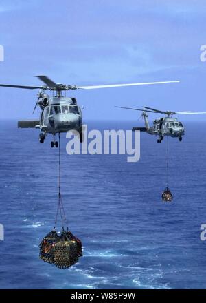 Zwei U.S. Navy Seahawk Helikopter Transfer liefert von der USS Camden (AOE2) an die Flight Deck des Flugzeugträgers USS Abraham Lincoln (CVN 72) während einer laufenden Auffüllen auf Sept. 11, 2004. Die Lincoln und seine eingeschifft Carrier Air Wing2 werden derzeit Operationen im Pazifischen Ozean in der Vorbereitung für eine bevorstehende Bereitstellung. Die Seahawks sind Hubschrauber Anti-Submarine Squadron 2 zugeordnet. Stockfoto