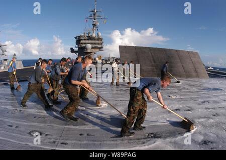 Matrosen an Bord der Flugzeugträger USS Kitty Hawk (CV 63) die Flight Deck schrubben nach dem Fly-off von Flugzeugen aus Carrier Air Wing 5 September 4, 2004. Schrubben entfernt den Film von Hydrauliköl, Öl und Kerosin auf dem Deck angesammelten und unterstützt die Traktion auf dem Flugdeck Oberflächen für Flugzeuge und Support Ausrüstung erhalten. Stockfoto