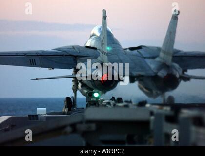 Eine F-14B Tomcat wird von der Flight Deck des Flugzeugträgers USS Harry S. Truman (CVN 75) während der Abendstunden Flugbetrieb im Persischen Golf am Dez. 4, 2004 katapultiert. Truman und seine eingeschifft Carrier Air Wing 3 sind, schließen die Unterstützung und Durchführung von Intelligence, Surveillance und Reconnaissance Missionen über den Irak. Der Tomcat wird auf Jagdgeschwader 32 zugeordnet. Stockfoto