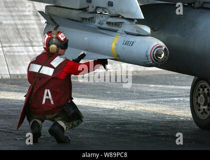 Petty Officer 3rd class William Miller Arme eine AGM-65 Maverick Laser - geführte Flugkörper auf eine F/A-18 Hornet montiert, bevor das Flugzeug aus dem Flight Deck des Flugzeugträgers USS Harry S. Truman (CVN 75) an November 28, 2004 gestartet wird. Die AGM-65 Maverick ist ein Luft-zu-Rakete für Close Air Support, Verbot und Verteidigung Unterdrückung entwickelt. Trumans Carrier Strike Group 10 und schiffte sich Carrier Air Wing 3 sind zur Unterstützung der globalen Krieg gegen den Terror eingesetzt. Miller ist ein Marine Aviation ordnanceman zu Strike Fighter Squadron 105 zugeordnet. Stockfoto