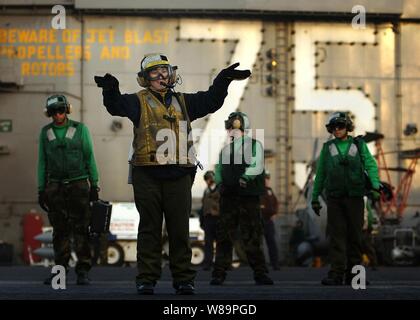 Marine Petty Officer 3rd Class Amanda Volino leitet der Pilot eines Flugzeugs vorbereiten, auf 21.01.2005, aus dem Flight Deck der USS Harry S. Truman (CVN 75) starten. Truman und schiffte sich Carrier Air Wing 3 leitend sind enge Luftunterstützung, Intelligence, Surveillance und Reconnaissance Missionen über die Golfregion in Unterstützung des Krieges gegen den Terror. Volino ist ein Marine Aviation Bootsmann Mate (Handler) an Bord der Flugzeugträger der Nimitz-Klasse. Stockfoto