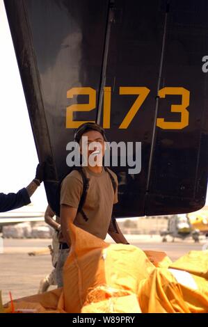 U.S. Navy Petty Officer 3rd Class Anthony Moreno hilft Hunderte lbs der Mail auf eine C-2 ein Greyhound bei Aviation Support Unit Bahrain am 15. Mai 2005. Der Greyhound ist Fleet Logistics Support Squadron 30 Das ist die Durchführung von Carrier Onboard Lieferung Logistik zugeordnet Unterstützung für die USS Carl Vinson (CVN 70). Die vinson Gruppe in den Arabischen Golf Durchführung Maritime Security Operations ist Streik. Moreno ist einer Marine, Aviation Maschinisten Mate. Stockfoto