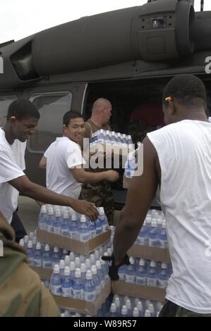 Us-Marine Seeleute und U.S. Army National Guard Mitglieder laden Wasser und Eis in ein UH-60 Black Hawk Hubschrauber bei Gulf Port International Airport in Biloxi, Fräulein, an Sept. 1, 2005. Departement für Verteidigung Einheiten werden als Teil der Gemeinsamen Task Force Katrina Katastrophe mobilisiert die Federal Emergency Management Agency-Hilfsmaßnahmen in den Gulf Coast Bereiche, die durch Hurrikan Katrina verwüstet zu unterstützen. Der Flughafen ist jetzt einer der wichtigsten Bereitstellflächen für Hurrikan-Hilfsmaßnahmen in Mississippi. Die Matrosen sind von der USS Bataan (LHD5), die in den Golf von Mexiko ca. 100 Meilen Sou Stockfoto