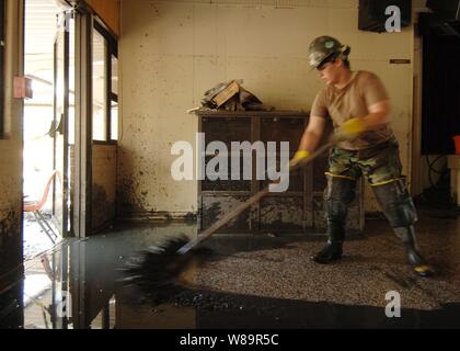 U.S. Navy Seabee Petty Officer 3rd Class Rebecca Newman schiebt schlammigen Wasser aus dem Inneren der Cafeteria in Unserer Lieben Frau von Lourdes katholische Schule in Slidell, La., Sept. 11, 2005. Departement für Verteidigung Einheiten werden als Teil der Gemeinsamen Task Force Katrina mobilisiert Katastrophenhilfe der Federal Emergency Management Agency in der Gulf Coast Bereiche, die durch Hurrikan Katrina verwüstet zu unterstützen. Newman ist der Marine builder Naval Mobile Konstruktion Bataillon 4 zugeordnet. Stockfoto