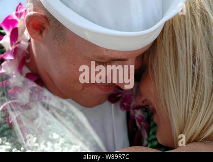 Marine Petty Officer 1st Class Benjamin Wolf umarmt seine Frau nach der Rückkehr in Pearl Harbor, Hawaii, von einem sechsmonatigen Einsatz an Bord der Lenkwaffen-zerstörer USS Chafee (DDG90) am 9. November 2005. Die chafee wurde als Teil der Nimitz Carrier Strike Group bereitgestellt. Stockfoto