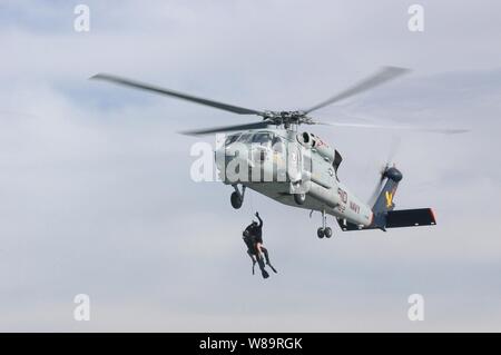 Eine Marine SH-60F Seahawk Hubschrauber Hebezeuge zwei Suche und Rettung Schwimmer aus der Bucht von San Diego während rescue Training in San Diego, Calif., Nov. 8, 2006. Die live Training erhöht die Betriebsbereitschaft und die Wirksamkeit der Piloten des Geschwaders, Aircrew Mitglieder und Rettungs Schwimmer. Das Seahawk und seine Crew sind zu Hubschrauber Anti-Submarine Squadron 2 der Naval Air Station North Island in San Diego vergeben. Stockfoto