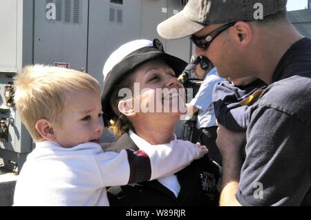 Marine Petty Officer 1st Class Nikki Krein grüßt ihre Familie, als sie in San Diego, Kalifornien, am 24.02.2006, zurück von einem 5-monatigen Einsatz an Bord der USS Pinckney (DDG91). Krein ist ein Marine yeoman an Bord der Arliegh Burke Klasse Zerstörer. Stockfoto