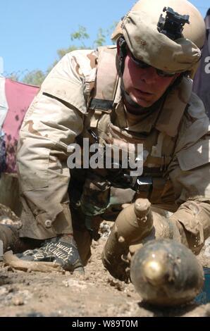 U.S. Navy Petty Officer 2nd class William Schofer zieht Ordnance im Schlamm in der Nähe eines verlassenen Gebäude in Bagdad, Irak, am 20. April 2006 begraben. Schofer und seine Kollegen die Beseitigung von Explosivstoffen Mobile Einheit sechs Seeleute 340 Anti-Personen-Minen und Granaten aus der Website erholt. Stockfoto