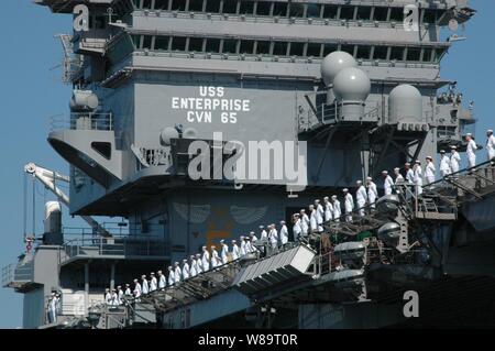 Crewmitglieder der USS Enterprise (CVN 65) Mann der Schiene als der Flugzeugträger fährt Naval Station Norfolk, VA. Für die Bereitstellung am 2. Mai 2006. Fast 7000 Segler aus dem Unternehmen Carrier Strike Group sind die Bereitstellung zur Unterstützung der Krieg gegen den Terror. Stockfoto