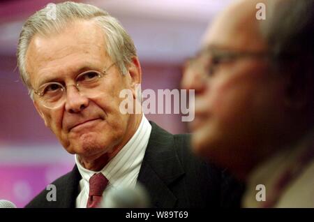 Verteidigungsminister Donald H. Rumsfeld hört als Indiens Minister für Verteidigung Pranab Mukherjee spricht mit Reportern während der Mittel Verfügbarkeit im Shangri-La Hotel in Singapur am 3. Juni 2006. Rumsfeld und Mukherjee sind in Singapur mit regionalen Verbündeten zu treffen und die fünfte jährliche Internationale Institut für Strategische Studien in Asien Security Konferenz als der Shangri-La-Dialog bekannt. Stockfoto