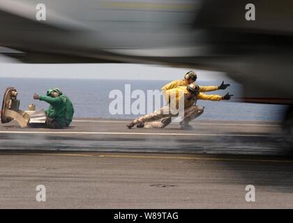 Eine F/A-18 Hornet beschleunigt Vergangenheit Flight Deck schützen an Bord der Flugzeugträger USS Theodore Roosevelt (CVN 71) als das Schiff den Flugbetrieb am 24. Juli 2006 leitet. Stockfoto