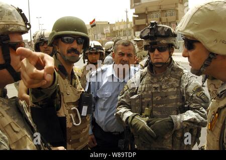 Us-Armee Oberst Thomas Vail (Zweiter von rechts), ein irakischer Polizist und der kommandierende Offizier des 6 irakische Armee Division besprechen, wo Sicherheit Personal in Bagdad, Irak, am 12.08.20, 2006 in Position zu bringen. Vail ist der kommandierende Offizier der 506th Regimental Combat Team, Luftlandedivision. Stockfoto