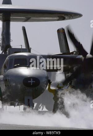 Ein U.S. Navy Flugzeug Direktor leitet das Pilotprojekt für eine E-2C Hawkeye die Flugzeuge an den Katapult für Start von Flight Deck des Flugzeugträgers USS Dwight D. Eisenhower (CVN 69) als das Schiff im Arabischen Meer an November 24, 2006 betreibt. Die Hawkeye ist die Marine von Alle-Wetter, Carrier-based Tactical Battle Management Airborne Early Warning, Kontrolle und Steuerung von Flugzeugen. Eisenhower im Arabischen Meer zur Unterstützung der Maritime Security Operations. Stockfoto