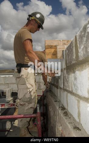 U.S. Navy Seabee Petty Officer 3. Klasse Bradley Clark glättet Mörtel, wie er die Wand für ein Mädchen Schule Wohnheim in Tadjoura, Dschibuti baut, Jan. 10, 2007. Clark ist ein Marine Builder mit Naval Mobile Konstruktion Bataillon 5 Combined Joint Task Force-Horn von Afrika. Stockfoto