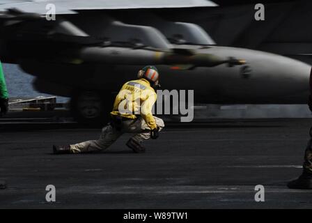 Ein U.S. Navy aircraft Start officer Enten nach unten, damit der Flügel eines F/A-18F Super Hornet über ihn als das Flugzeug katapultiert aus dem Flight Deck des Flugzeugträgers USS John C Stennis (CVN 74) Am 28. März 2007 zu übermitteln. Die Stennis Carrier Strike Group und ihre Eingeschifft Carrier Air Wing 9 Führen ein Dual-träger Übung mit der Eisenhower Carrier Strike Group und Carrier Air Wing 7 im Persischen Golf. Stockfoto