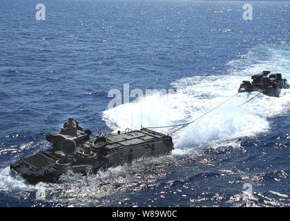 Us-Marines Antrieb ein Amphibisches Fahrzeug wie es schleppt ein weiteres Fahrzeug aus dem Camp Schwab, Okinawa, amphibious Transport dock Schiff USS Juneau LPD (10) in den Pazifischen Ozean am 21. Mai 2007. Die Juneau ist die Task Force 76, von Sasebo, Japan betreibt zugeordnet. Stockfoto