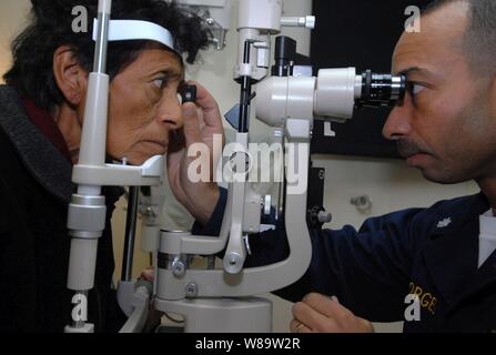 U.S. Navy Augenarzt Cmdr. Octavio Borges (rechts) untersucht, Susana Mendoza, eine peruanische Patienten, an Bord der Hospital Ship USNS Comfort (T-AH 20) vor der Küste von Peru am August 6, 2007. Die Military Sealift Command Krankenhaus Schiff ist auf vier - Monat humanitären Einsatz in Lateinamerika und der Karibik medizinischer Behandlung von Patienten aus einem Dutzend Ländern zur Verfügung zu stellen. Stockfoto