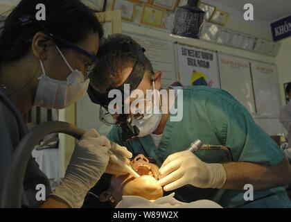 Us Navy Lieutenant Kevin Haveman, zusammen mit einem Dental Assistant von der Ost trifft West zahnmedizinisches Programm, reinigt die Zähne eines vietnamesischen Frau am Nai Hiem Dong medizinische Station in der Stadt Da Nang, Vietnam, am 24. Juli 2007. Haveman ist mit der 3. Medizinischen Bataillon und wird zur Unterstützung der pazifischen Partnerschaft, eine humanitäre Mission in Südostasien und Ozeanien mit spezialisierten medizinischen Versorgung und verschiedene Konstruktions- und Engineering Projekten eingesetzt. Stockfoto