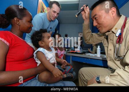 U.S. Public Health Service Lt.Cmdr. Harry Ko verwendet eine Taschenlampe, um die Aufmerksamkeit von Joel Richards zu fangen, während er durch seine Mutter Eira am Paul Brown Arena in Colon, Panama, am 6. Juli 2007. Ko ist die militärische Sealift Command Hospital Ship USNS Comfort (T-AH 20) beigefügt. Der Komfort ist auf vier Monate humanitärer Einsatz in Lateinamerika und der Karibik medizinischer Behandlung von Patienten aus einem Dutzend Ländern zur Verfügung zu stellen. Stockfoto