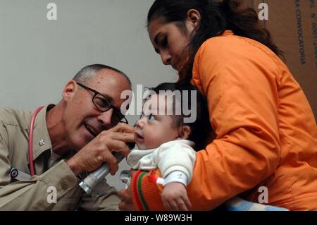 U.S. Navy Cmdr. Craig Martin untersucht ein Baby am Jose F. Sanchez Aas Schule in Trujillo, Peru, am 12.08.2007. Martin ist zum Krankenhaus ship USNS Comfort (T-AH 20) beigefügt. Die Military Sealift Command Krankenhaus Schiff ist auf vier - Monat humanitären Einsatz in Lateinamerika und der Karibik medizinischer Behandlung von Patienten aus einem Dutzend Ländern zur Verfügung zu stellen. Stockfoto