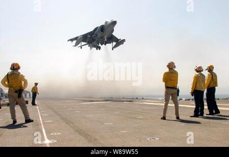 U.S. Navy Flight Deck Crew watch ein Marine AV-8B Harrier Land auf dem Flugdeck des Amphibious Assault ship USS BONHOMME RICHARD (LHD6) während in den Persischen Golf an Sept. 15, 2007. Die vertikale/kurze Start- und Landebahn Jet der Marine Expeditionary Unit 13 angeschlossen ist, Air Combat Element. Stockfoto