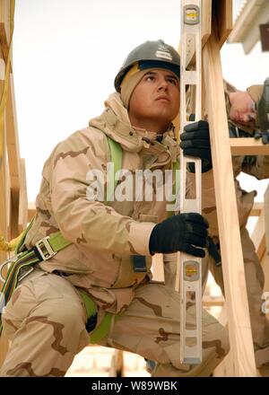 U.S. Navy Seabee Petty Officer 3rd Class Adam Turbeville prüft die Plumb einer Truss, während der Bau einer Fellowship Hall im Camp Ramadi, Irak, Dez. 20, 2007 arbeiten. Die Halle wird verwendet werden Konferenzen, Feiern und Gottesdienste zu veranstalten, und wird auch als Ort für Service Mitglieder zum Entspannen dienen. Turbeville ist ein Marine Builder Naval Mobile Konstruktion Bataillon 1 zugewiesen. Stockfoto