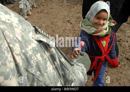 Ein Soldat der US-Armee gibt einen irakischen Mädchen einen Lutscher während einer kooperativen medizinischen Austausch in der Stadt Al Abur in der Provinz Diyala des Irak am 15.Februar 2008. Soldaten aus dem Armyís 2nd Squadron, 1st Cavalry Regiment sind die Durchführung der medizinischen Austausch zusammen mit irakischen Armee medizinisches Personal. Stockfoto