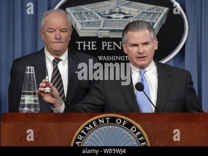 Principal stellvertretender Staatssekretär der Verteidigung für Politik Ryan Henry (rechts) hält bis Teil einer mock Nasenkonus Baugruppe für einen Minuteman Rakete während einer Pressekonferenz mit Luftwaffe Sekretär Michael W. Wynne in das Pentagon in Arlington, Va., am 25. März 2008. Henry und Wynne beschrieben zu den Reportern, wie einige nicht-nuklearen Nasenkonus Baugruppen wurden irrtümlich im Jahr 2006 nach Taiwan geschickt und der unmittelbaren Kontrolle des Fischereiaufwands der Baugruppen, wieder einmal die errant Sendung entdeckt wurde. Stockfoto