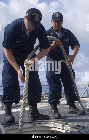 U.S. Navy Seaman Corey Rea (links) und Petty Officer 3rd Class Mark Alejandro stow eine Leine an Bord der Lenkwaffen-zerstörer USS John S. McCain (DDG56) nach einem Tankstopp in Apra Harbor, Guam, am 22. Juli 2008. Die McCain ist einer von sieben der Arleigh-Burke-Klasse Lenkflugkörper Zerstörer Zerstörer Geschwaders 15 zugewiesen. Stockfoto
