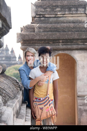 Eine sehr glückliche Frau Tourist und eine Burmesische Junge mit den traditionellen Thanaka Make-up auf im alten Tempel in Bagan Myanmar & Frau freigegeben. Stockfoto