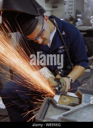 U.S. Navy Petty Officer 3. Klasse James Engling schleift Burs aus einem Stück Metall nach dem Schweißen im Blech Shop an Bord der Flugzeugträger USS John C Stennis (CVN 74) im Pazifischen Ozean am Februar 6, 2009. Die Stennis ist auf einen sechsmonatigen Einsatz in den Westpazifik. Stockfoto