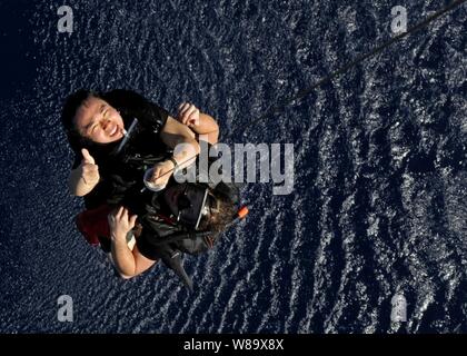 U.S. Navy Petty Officer 2. Klasse Kelvin Y. Chen (links) und Petty Officer 2nd class Kevin M. Abney, Suche und Rettung Schwimmer der USS Blue Ridge (LCC 19), aus der das Wasser durch ein SH-60F Seahawk Hubschrauber während einer Übung im Pazifischen Ozean am 13.02.18, 2009 gezogen. Stockfoto