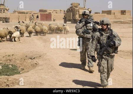 Us-Armee Soldaten aus grünen Platoon, 1.Bataillon, 24 Infanterie Regiment, 1 Stryker Brigade Combat Team, 25 Infanterie Division Security bieten, während Soldaten aus 2.Bataillon, 19 Brigade, 5 irakische Division humanitäre Hilfe für die Dorfbewohner in Shuzayf, Irak, am 27. März 2009. Stockfoto