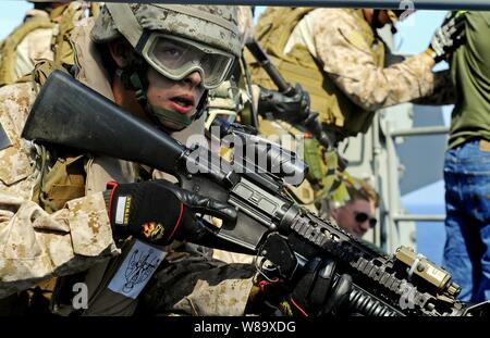 Ein US-Marine mit dem Besuch, Board, Durchsuchung und Beschlagnahme Team auf den 22 Marine Expeditionary Unit startete an Bord amphibische Landung dock Schiff USS Fort McHenry (LSD 43) steht als Ausblick, während andere Teammitglieder suche Gefangenen während einer nicht konformen Handelsschiff Bohrer in den Atlantischen Ozean am 26. Mai 2009. Das Fort McHenry ist auf Bereitstellung mit der USS Bataan (LHD 5) amphibische Bereitschaft Gruppe, die Maritime Security Operations in den USA am 5. und 6 Flotte Verantwortungsbereiche. Stockfoto