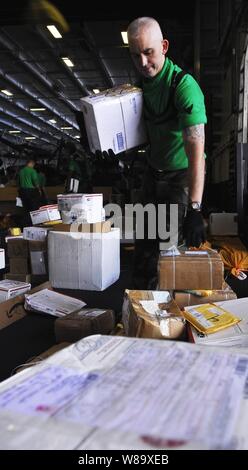 U.S. Navy Petty Officer 2nd class Damion Kelley Art mail im Hangar Bay an Bord der Flugzeugträger USS John C Stennis (CVN 74) während einer Auffüllung auf See mit der Flotte Auffüllung öler USNS John Ericsson (T-AO 194) im Pazifischen Ozean am 20. Mai 2009. Die Stennis ist auf einen sechsmonatigen Einsatz in den Westpazifik. Stockfoto