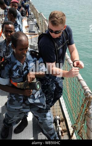 U.S. Navy Petty Officer 1st Class James Harry Züge Djiboutian Segler im Schlauch - Handhabung von Techniken auf dem Flugdeck der geführten Anti-raketen-Zerstörer USS Arleigh Burke (DDG51) in Dschibuti am 11. Juni 2009. Die Arleigh Burke ist als Teil von Afrika Partnerschaft Station", einer internationalen Initiative entwickelt von Naval Forces Europe und Seestreitkräfte Afrika maritime Sicherheit rund um den afrikanischen Kontinent zu verbessern. Stockfoto