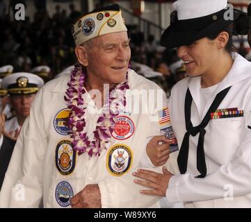 Woody Derby, eine Pearl Harbor Überlebenden, begleitet von U.S. Navy Petty Officer 3. Klasse Kathleen McDowell ehrt die USS Nevada (BB 36) wie sie Pearl Harbor Tag in Pearl Harbor, Hawaii feiern, am 7. Dezember 2009. Der National Park Service und der US-Marine sind Hosting einer gemeinsamen Gedenkveranstaltung mit mehr als 2.000 verehrte Gäste, der Öffentlichkeit und der Militärs, die aktive und pensionierte, der 68. Jahrestag des Angriffs auf Pearl Harbor zu gedenken. Das Thema der Veranstaltung war "aber nicht in Schande: Die Hinterlassenschaft von Pearl Harbor". Stockfoto