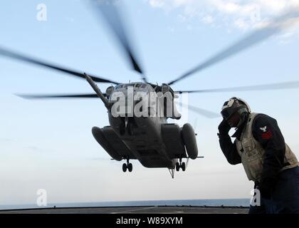 U.S. Navy Petty Officer 1st Class David Brown, ein Flight Deck Sicherheitsbeauftragter, hört zu, wie die Kommunikation am Hubschrauber control tower als Marine Corps CH-53 Sea Stallion Hubschrauber landet auf dem Flugdeck an Bord der Station Landung Schiff USS Tortuga (LSD 46) an November 5, 2009. Die Tortuga ist Teil der USS Denver LPD (9) Amphibious Task Group, die der jährlichen bilateralen Koreanischen integrierte Ausbildung Übung mit den Angriff 31 Marine Expeditionary Unit. Stockfoto