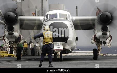 Ein Flugzeug Direktor führt eine C-2A Greyhound Flugzeuge auf dem Flugdeck an Bord der Flugzeugträger USS Harry S. Truman (CVN 75) nach Abschluss des täglichen Flugbetrieb während der Fahrt in den Atlantik führen Träger Qualifikationen am Dez. 8, 2009. Stockfoto