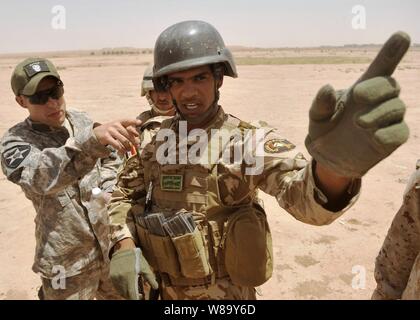 Us Army 1st Lieutenant J.D. Caddell (links), von der Bravo Company, 5 Bataillon, 20 Infanterie Regiment, 3 Stryker Brigade Combat Team, 2 Infanterie Division, erörtert die Manöver mit einen Team Leader aus dem irakischen Commando Bataillon, 18 Brigade vor einem Squad live-fire Übung an Kirkush Truppenübungsplatzes, der Provinz Diyala, Irak, am 27. Juni 2010. Stockfoto