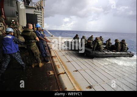 U.S. Navy Matrosen und Marines erholen bekämpfen Gummi Aufklärung Handwerk besetzt von Marines zur 31 Marine Expeditionary Unit am Heck Tor der Amphibischen dock Landung Schiff USS Harpers Ferry (LSD 49) während der Fahrt im philippinischen Meer an Sept. 19, 2010. Die Harpers Ferry ist auf Patrouille im westlichen Pazifischen Ozean als Teil der Essex Amphibious Ready-Gruppe, die in der Valiant Shield 2010 beteiligt ist. Die integrierte gemeinsame - Training wurde entwickelt, um die Interoperabilität zwischen den US-Streitkräften zu verbessern. Stockfoto