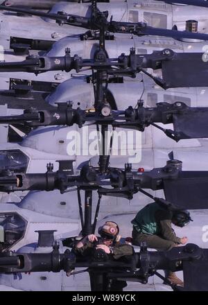 Us Marine Corps Lance Cpl. Christopher Horvet (links) in Marine Attack Squadron 542 zugewiesen, führt die Wartung auf dem Rotor eines AH-1Z Super Cobra Helikopter an Bord der Vorwärts - bereitgestellt Amphibisches Schiff USS Essex (LHD2) während der Fahrt im philippinischen Meer an Sept. 25, 2010. Stockfoto