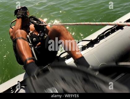 U.S. Navy Petty Officer 2nd class Robert Rechnungen, um kombinierte Task Group 56.1 zugewiesen sind, tritt das Wasser während einer Antiterrorism und Schutz tauchen in Manama, Bahrain, am Okt. 13, 2010. Der Tauchgang war mit Seglern aus Mobile Tauchen und Bergung Einheit 2, die als Teil des kombinierten Task Group 56.1 bereitgestellt Maritime Security Operations und Theater Sicherheit Zusammenarbeit in den USA 5 Flotte Verantwortungsbereich zu unterstützen wurde durchgeführt. Stockfoto